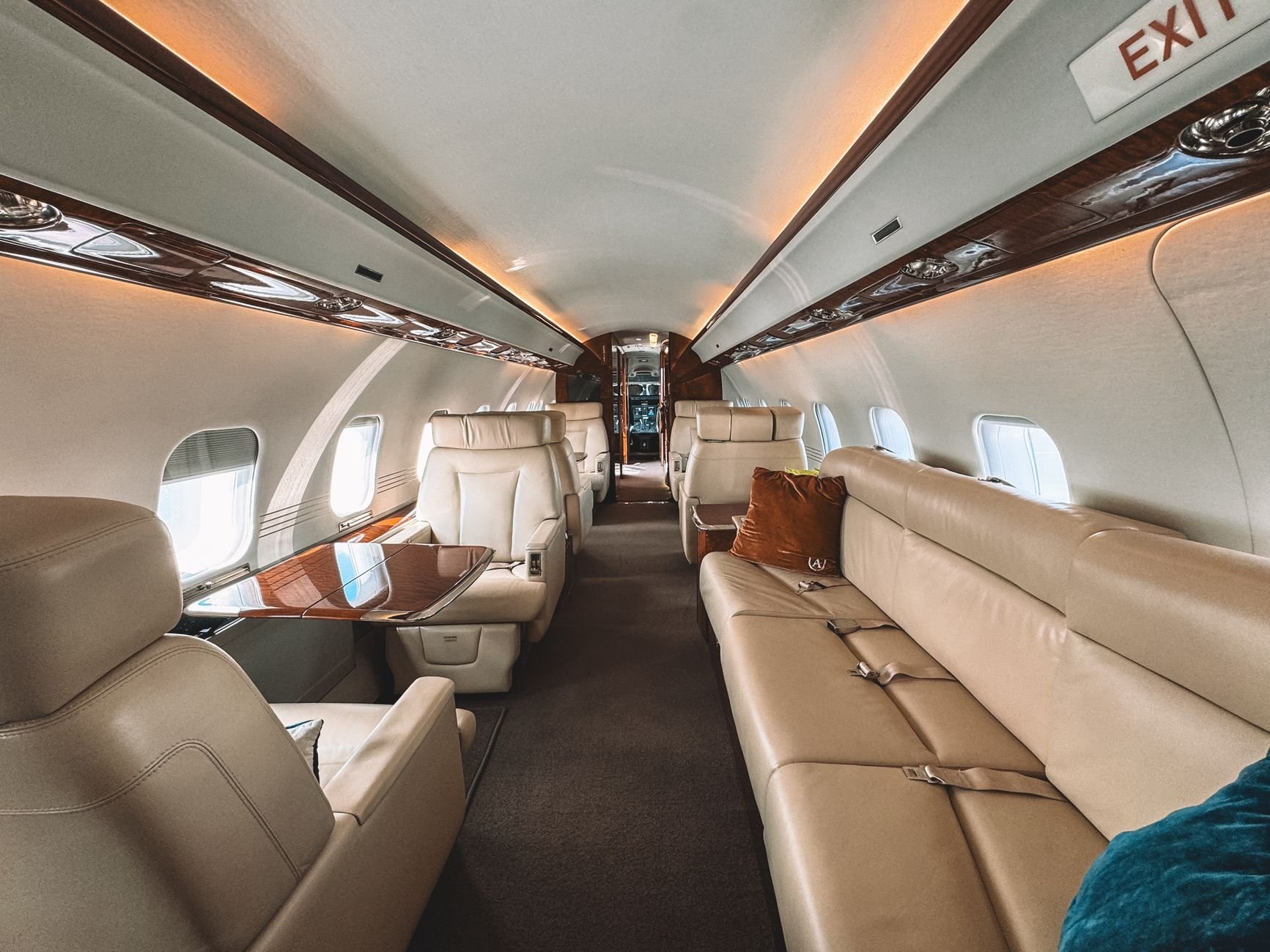 Luxury private jet cabin with leather seats and warm wooden trim